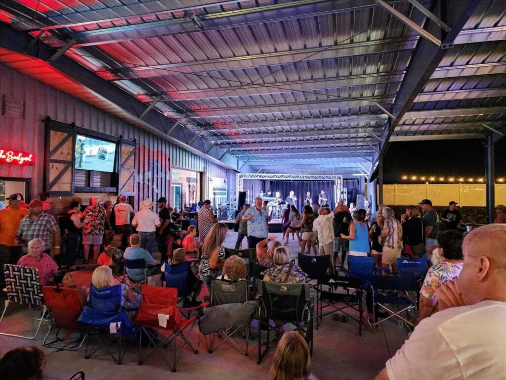 A crowd of people dancing and watching live musicians in an interior space