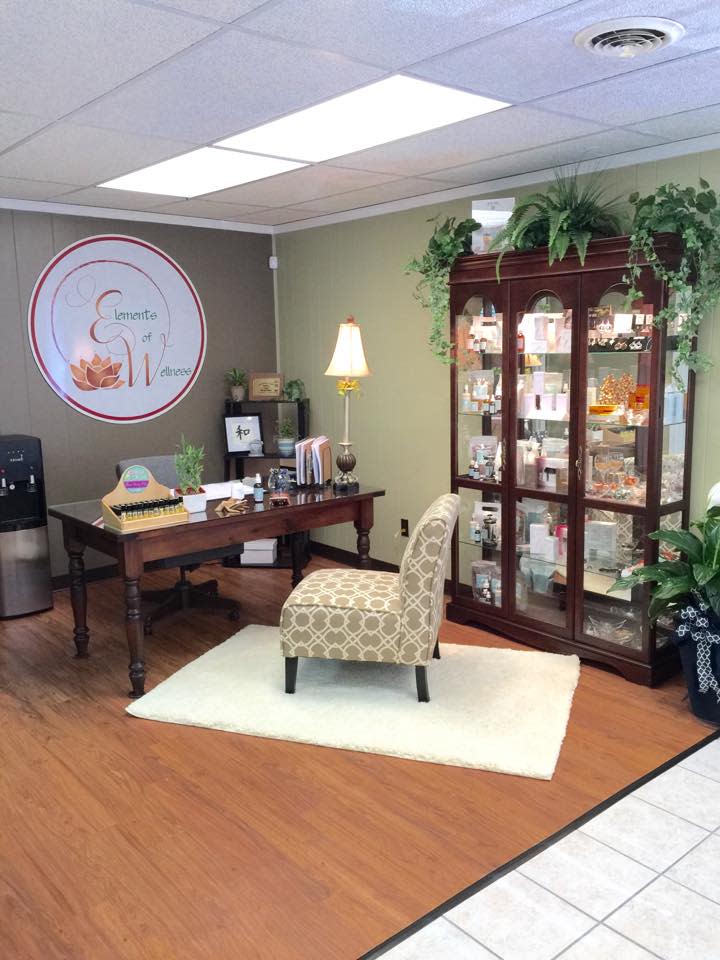 A desk with an upholstered armchair in front and a china cabinet filled with items on one side