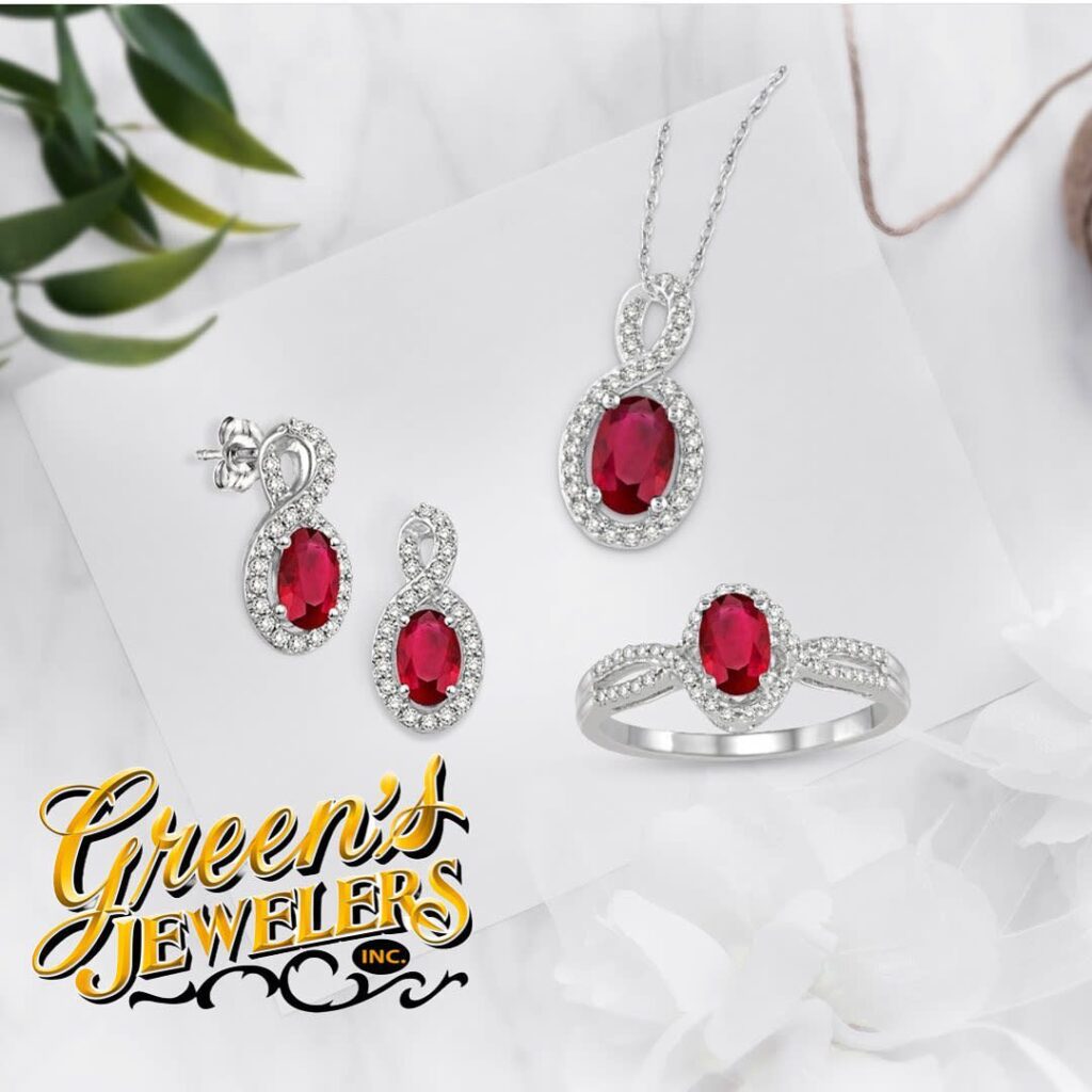 A matching set of earrings, necklace and ring with red center stones and halos of white stones