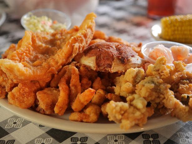 Fried shrimps on a white plate sitting on a black and white tablecloth