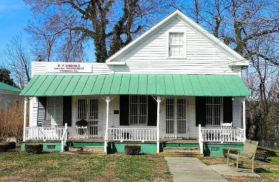 A white house with a green porch roof