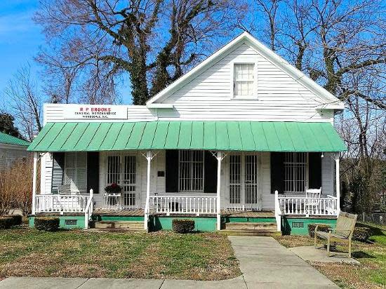 A white house with a green porch roof
